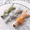 Three knitted animal dog chew toys (a wolf, an elephant, and a lion) on a surface with a lettered background