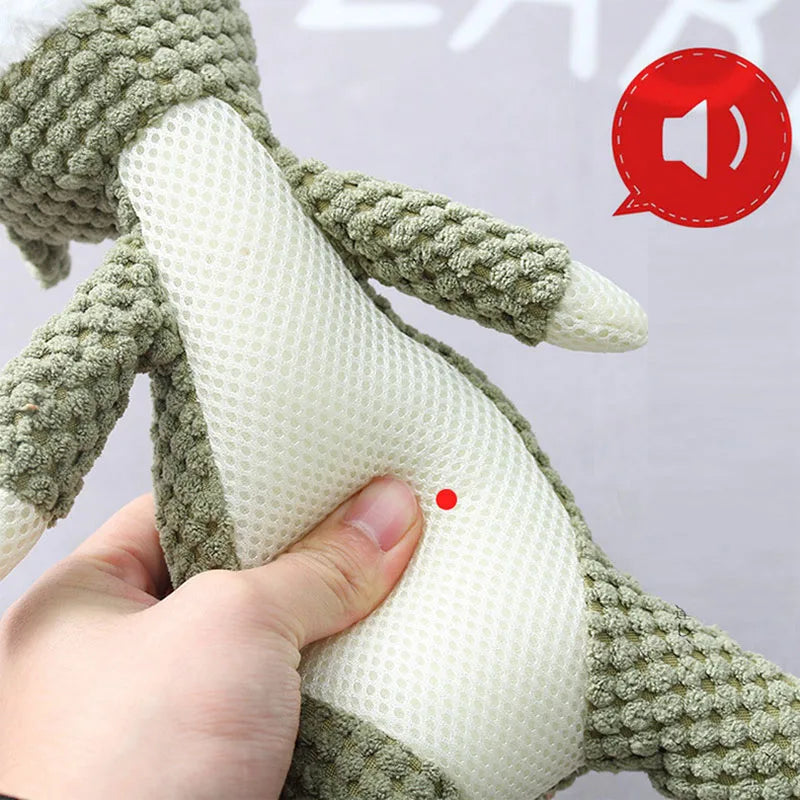 Hand holding a green knitted toy with a white textured center, on a light gray background featured the ability of a built-in squeaker